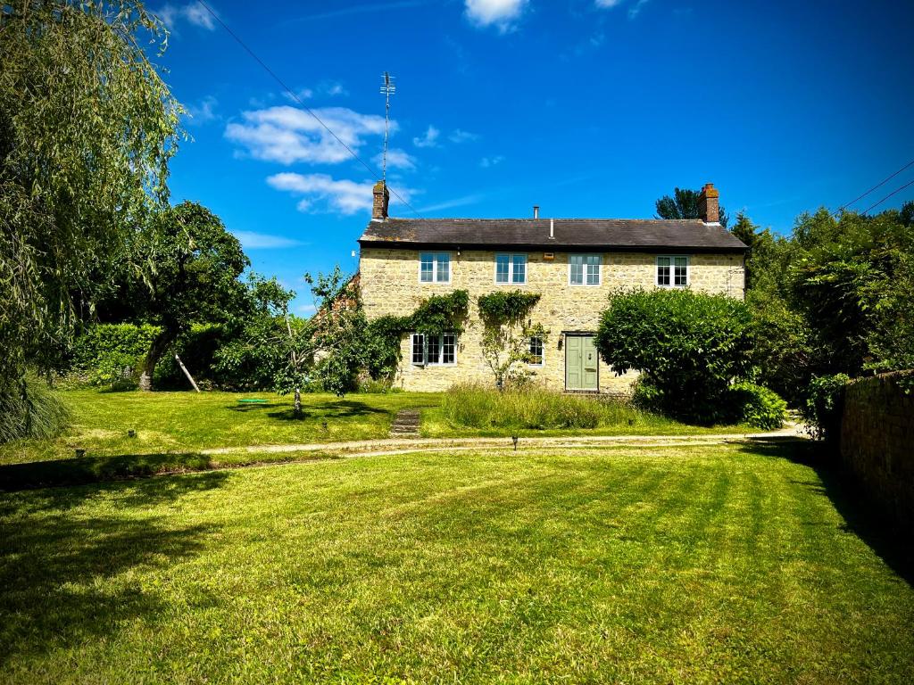 a large house with a large window in a grassy area at Home Farm Bed & Breakfast in Milton Keynes