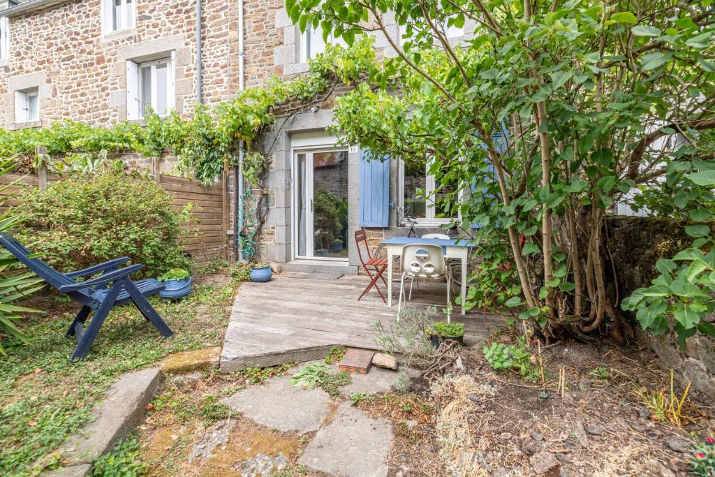 a patio with a blue bench and a table at La Maison des Fées in Pleudihen-sur-Rance