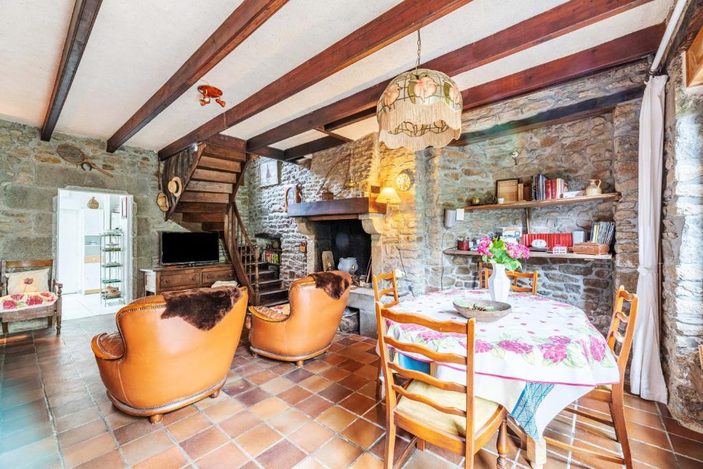 a dining room with a table and leather chairs at La Maison des Fées in Pleudihen-sur-Rance