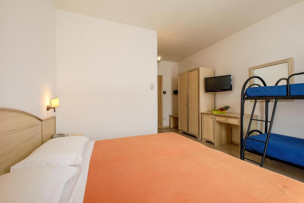 a bedroom with two bunk beds and a television at Hotel Corallo in Torre Santa Sabina
