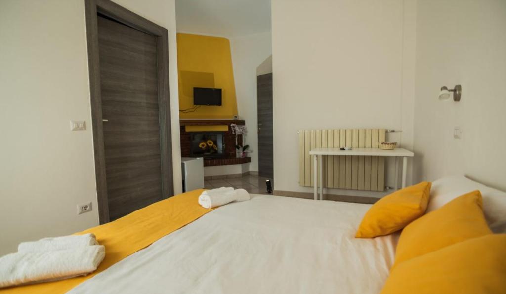 a bedroom with a large white bed with yellow pillows at Bed and Breakfast La Marianaccia in Marsiliana
