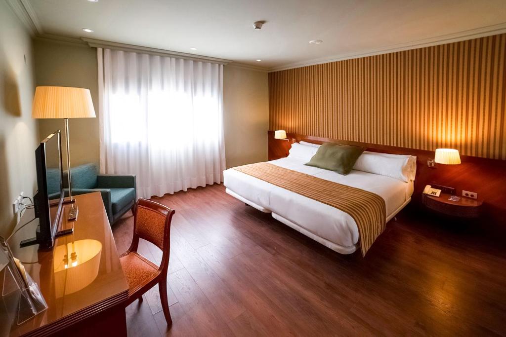 una habitación de hotel con una cama y un escritorio en Hotel Torremangana, en Cuenca