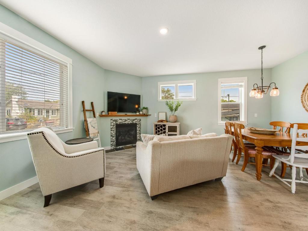 a living room with a table and chairs and a fireplace at Seaside Treasure in Seaside