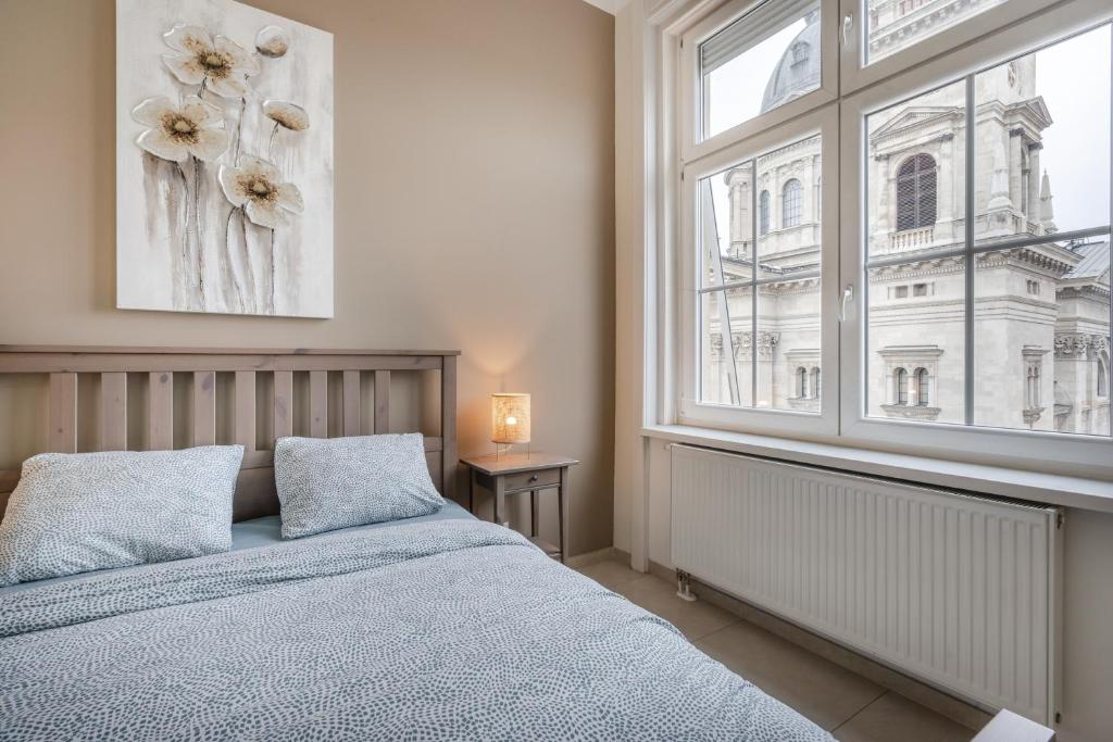 1 dormitorio con cama y ventana grande en Basilika Monnalisa luxury 3 bedrooms apartment with amazing view NEED RESERVATION X FREE PARKING en Budapest