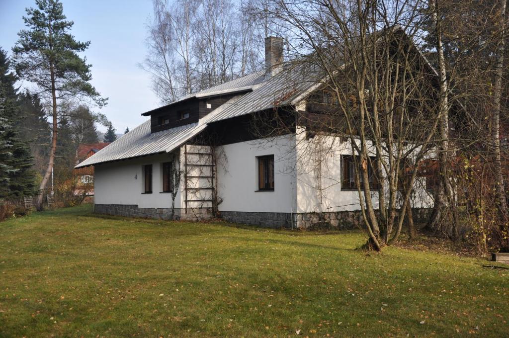 an old white house in the middle of a yard at Privát - Harrachov 392 in Harrachov