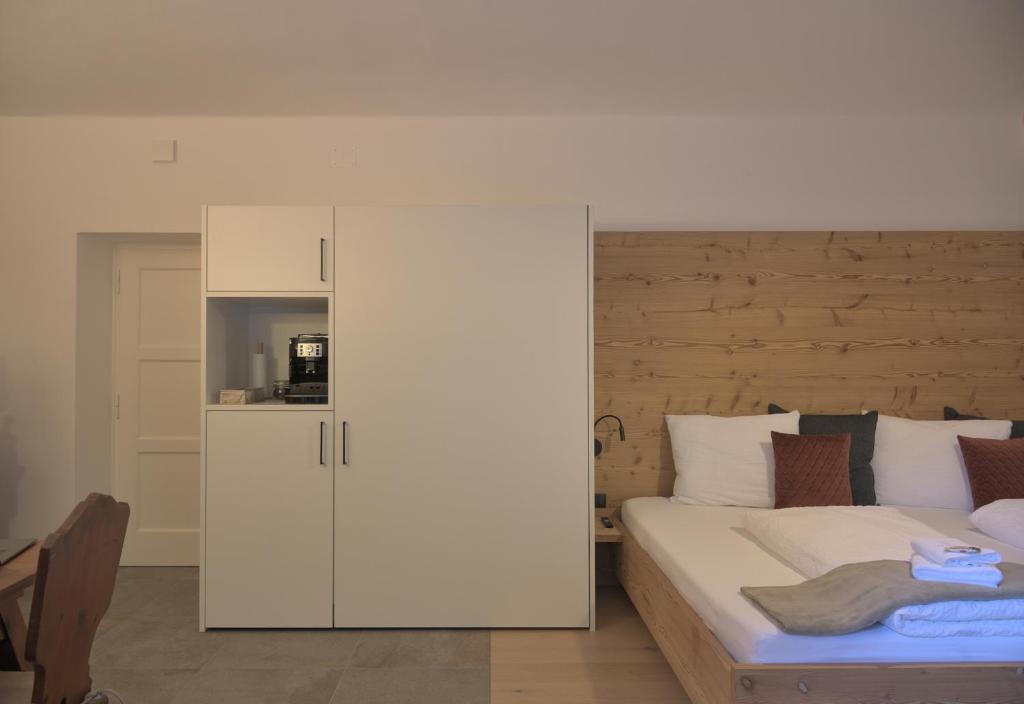 a bedroom with a bed and a white cabinet at CityChalet romantic Bozen in Bolzano