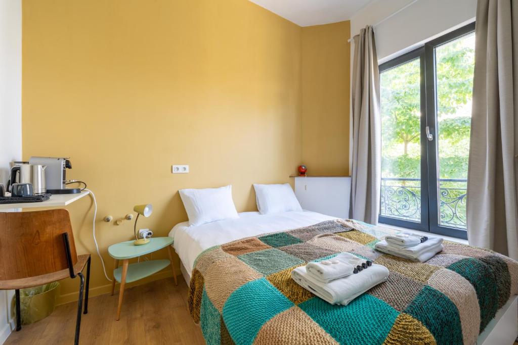 um quarto com uma cama, uma secretária e uma janela em Charming Apartments near Avenue Louise em Bruxelas