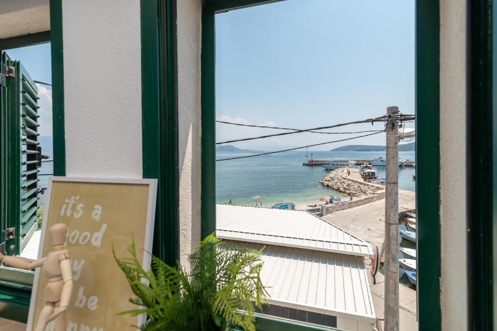 a window with a view of a beach and the ocean at Beach Apartman Marela in Slatine