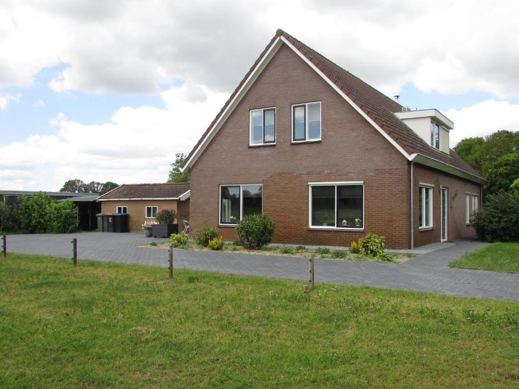 a large brick house with a driveway at De Steerne, mooie plek aan het Overijssels kanaal. in Schalkhaar