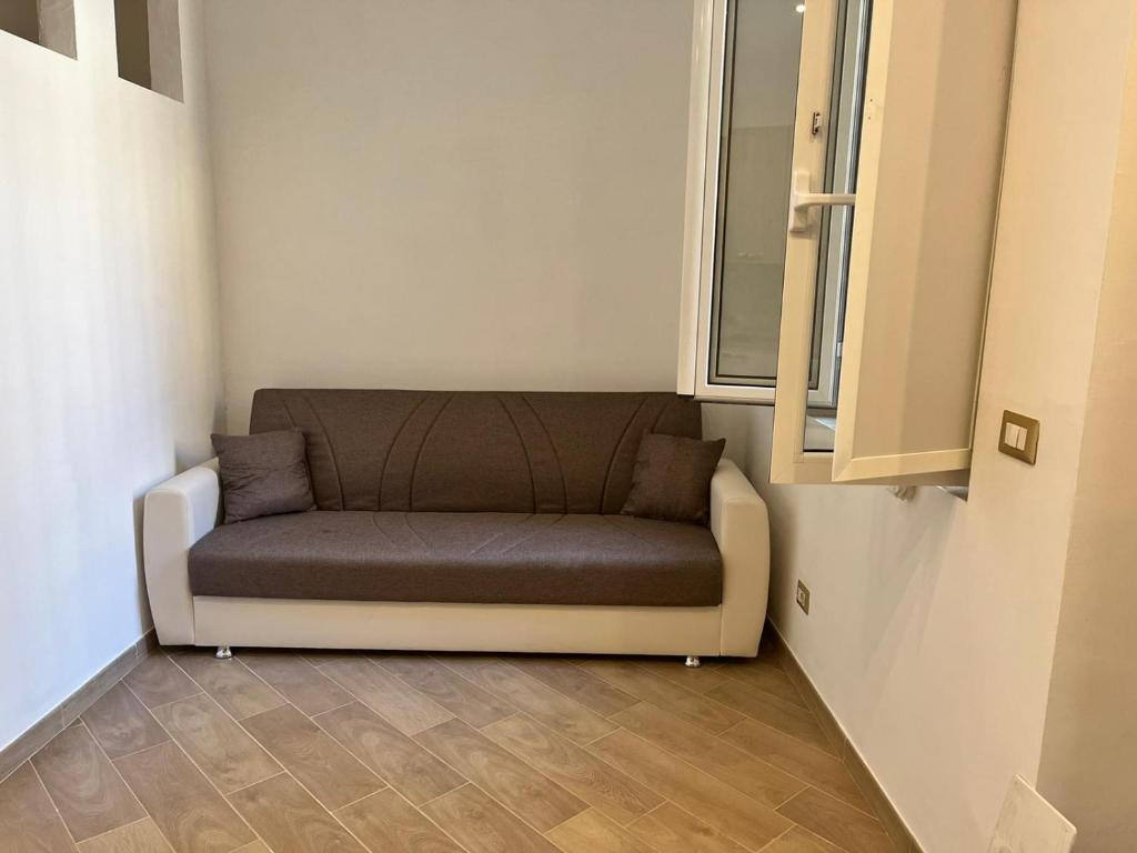ein Sofa in einem Zimmer mit Fenster in der Unterkunft A casa di Alessandra in Mailand