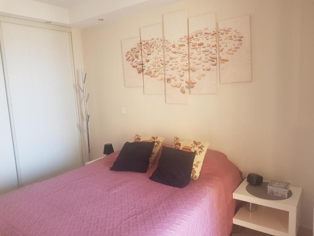 - une chambre avec un lit rose et 2 oreillers dans l'établissement Beau appartement avec garage fermé, à Beausoleil