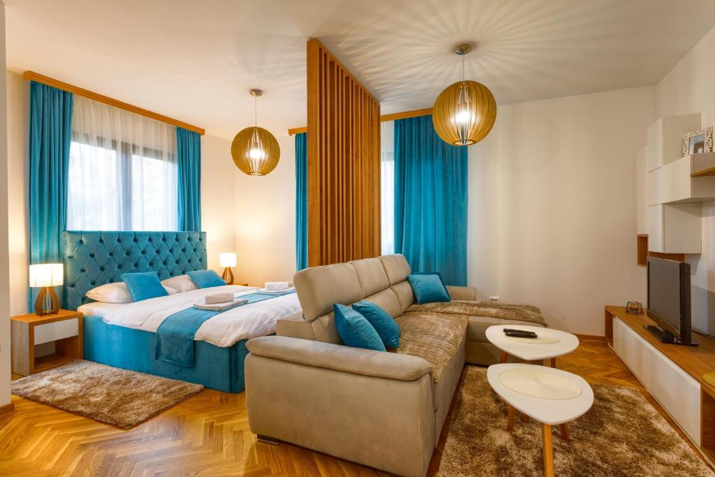 um quarto com uma cama, um sofá e uma televisão em Apartmani Stojanović Zlatibor em Zlatibor