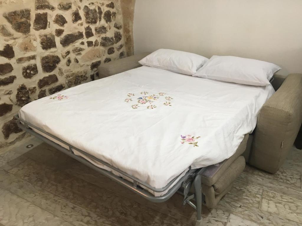 a bed with a white comforter with flowers on it at La Casetta in Altamura