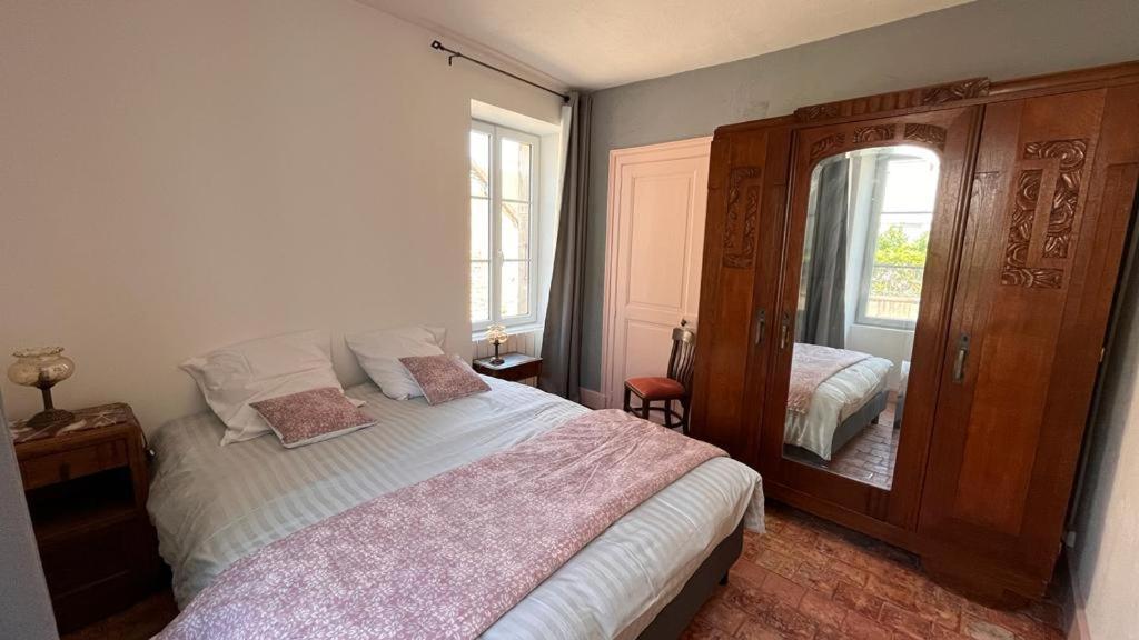 1 dormitorio con 1 cama grande y espejo en Chez Loulou - La suite, en Lainsecq