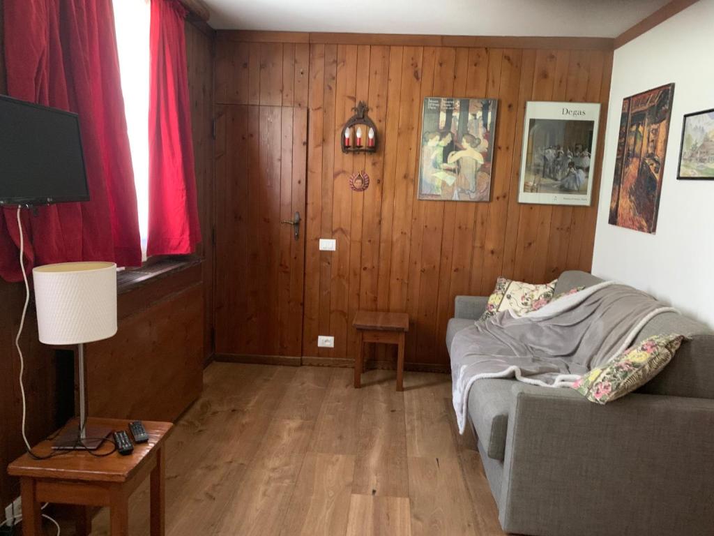 ein Wohnzimmer mit einem Sofa und einem TV in der Unterkunft renovated studio ski in ski out, CIR 0282 in Breuil-Cervinia