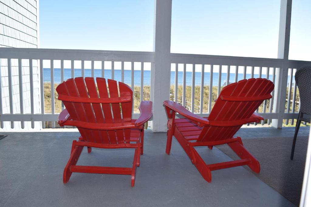 two red chairs sitting on top of a balcony at CB45 2B at the Beach in Carolina Beach