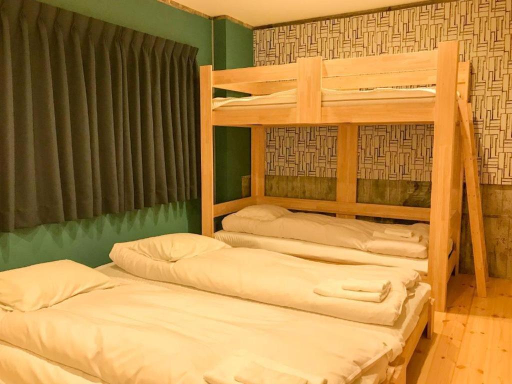 高松的住宿－Konyamachi Guest House Kuku - Vacation STAY 80155v，带两张双层床的绿色墙壁客房