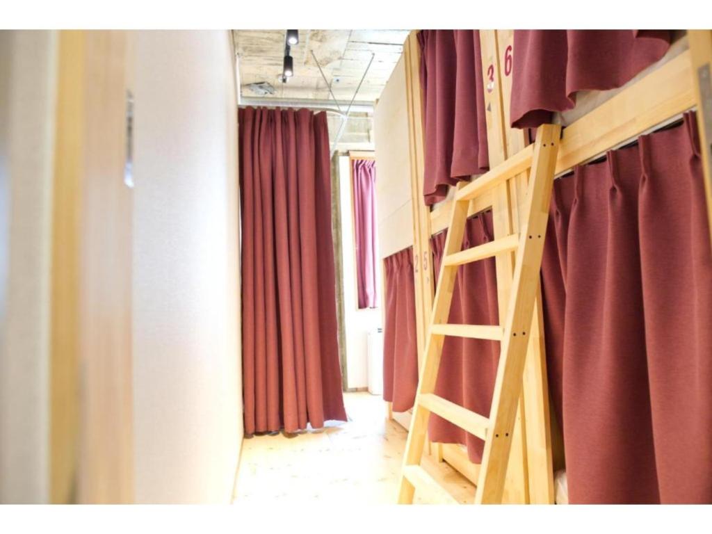 a staircase in a room with red curtains at Konyamachi Guest House Kuku - Vacation STAY 72725v in Takamatsu