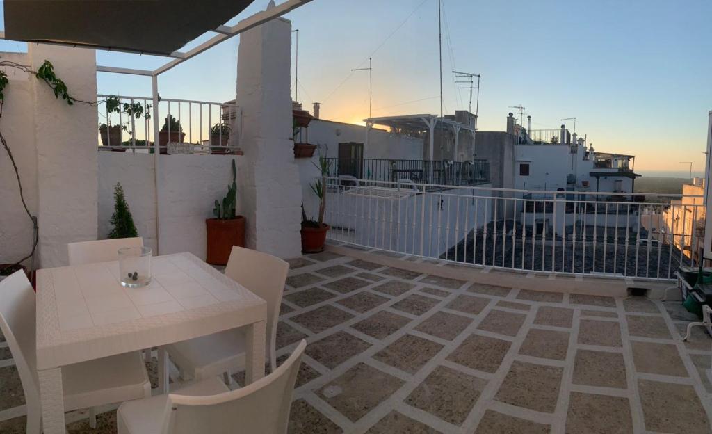 a patio with a white table and chairs on a balcony at Casa Sunshine in Ostuni