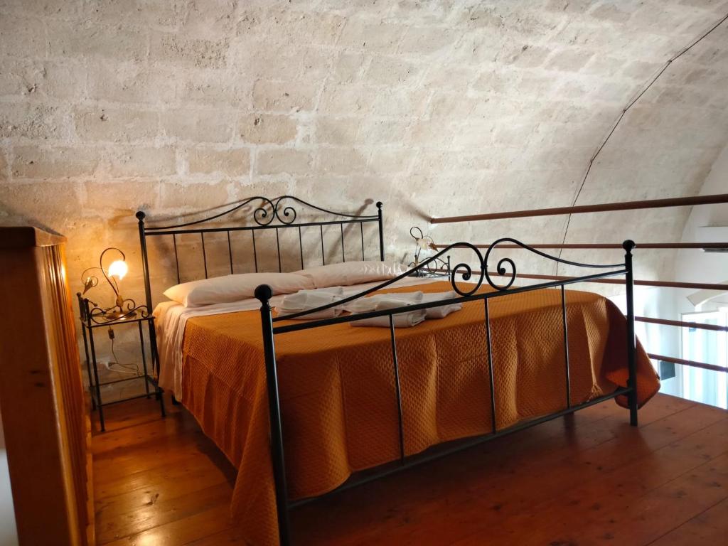 マテーラにあるB&B Il Caminettoのベッドルーム1室(金属製ベッド1台、オレンジの毛布付)