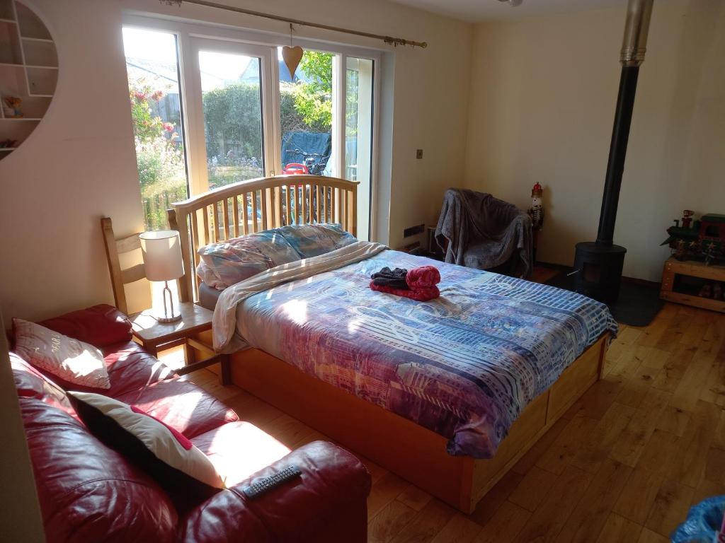 a bedroom with a bed and a couch and a window at No 9 Manor Way in Carmarthen