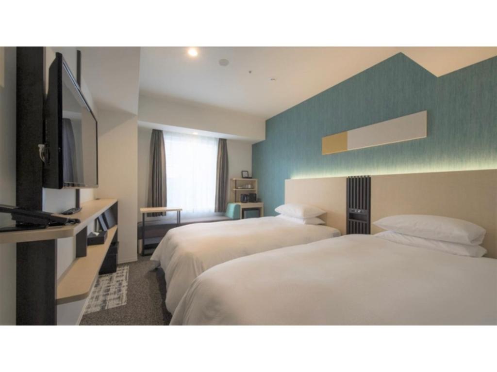 a hotel room with two beds and a flat screen tv at Tmark City Hotel Sapporo Odori - Vacation STAY 85615v in Sapporo