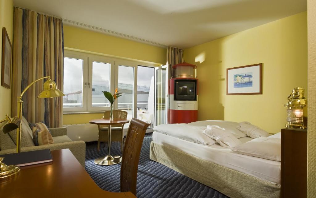 シュトラールズントにあるウィンダム シュトラールズント ハンセドムのベッドとリビングルームが備わるホテルルームです。