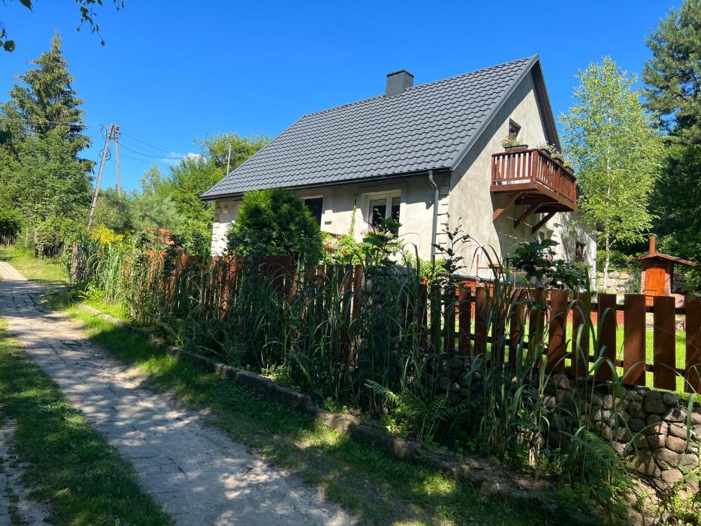 una casa con una valla de madera junto a una carretera en Dom nad jeziorem Strażym, en Zbiczno