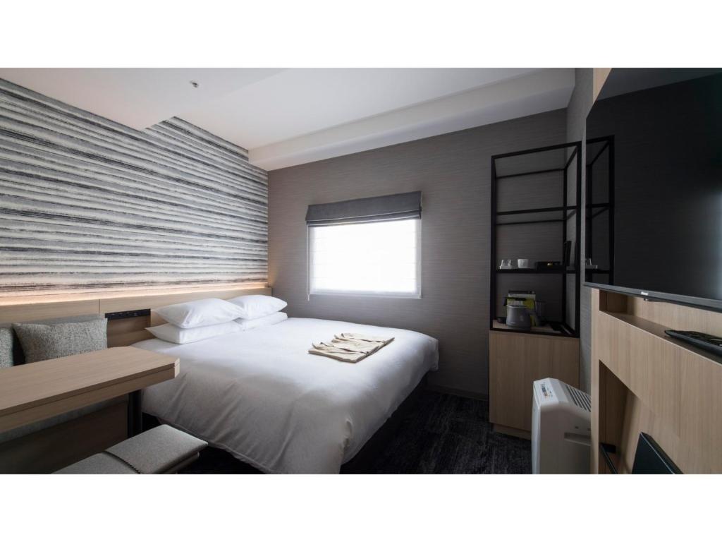 a hotel room with a bed and a window at Tmark City Hotel Kanazawa - Vacation STAY 90378v in Kanazawa