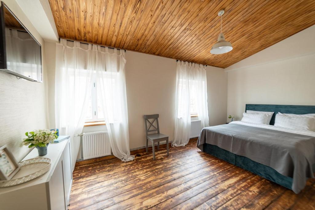 a bedroom with a bed and a wooden ceiling at Apartaments Nr. 33 ( Viesu Nr. 4) in Talsi