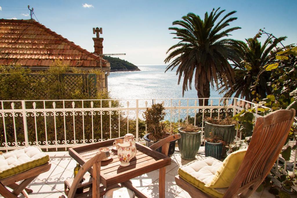 une terrasse avec une table et des chaises et l'océan dans l'établissement Secret Garden Apartment by Irundo, à Dubrovnik