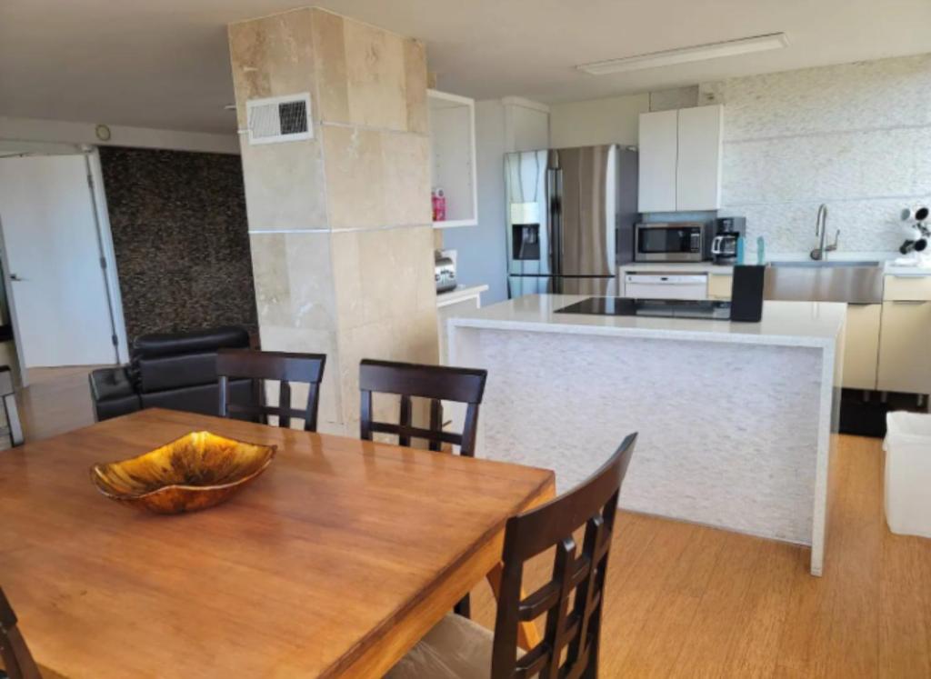 a kitchen and dining room with a wooden table and chairs at Apartment With Beautiful View in Hawaii in Honolulu