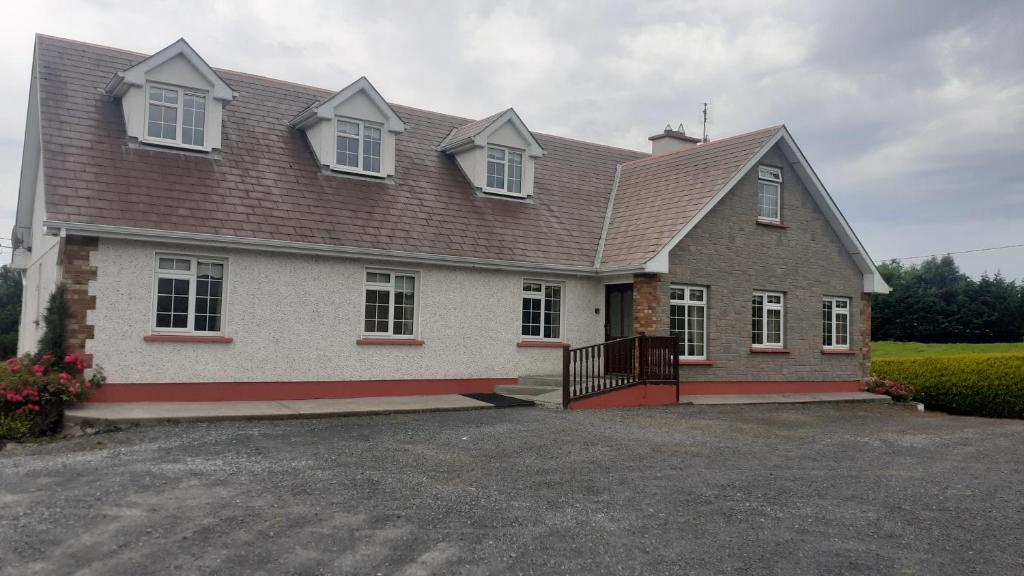 una gran casa blanca con techo en Spacious 6 Bed House 10 minutes from Knock Airport en Ballaghaderreen