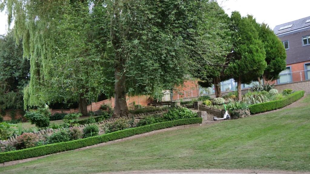 a person sitting on a bench in a garden at MK Shortstay Deluxe in Milton Keynes