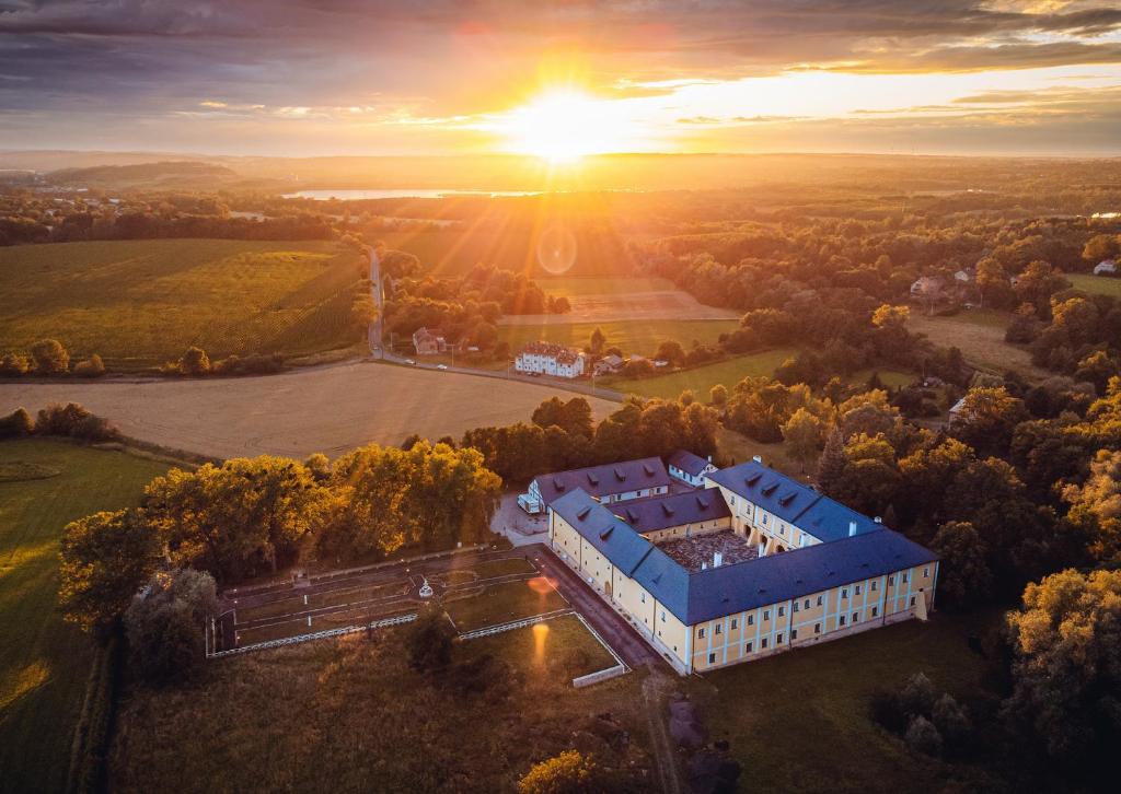 an aerial view of a building with the sunset in the background at Château Rychvald in Ostrava