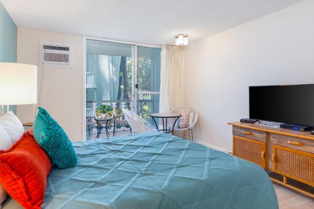 a bedroom with a large bed and a television at Kona Islander Inn 112 in Kailua-Kona