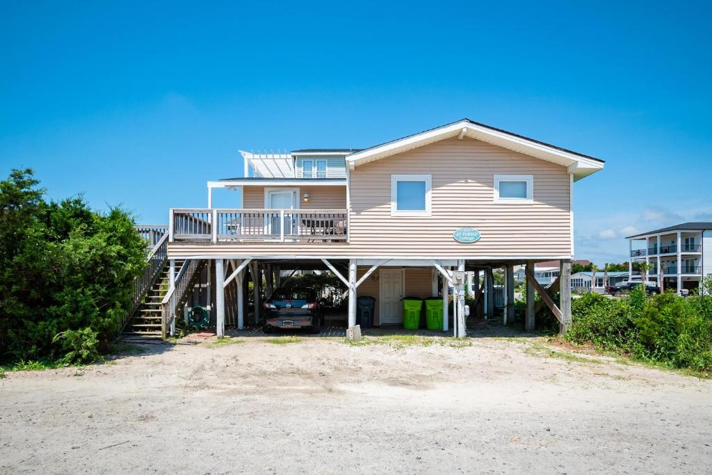 duży dom z tarasem na plaży w obiekcie At Turtle Cottage by Oak Island Accommodations w mieście Oak Island