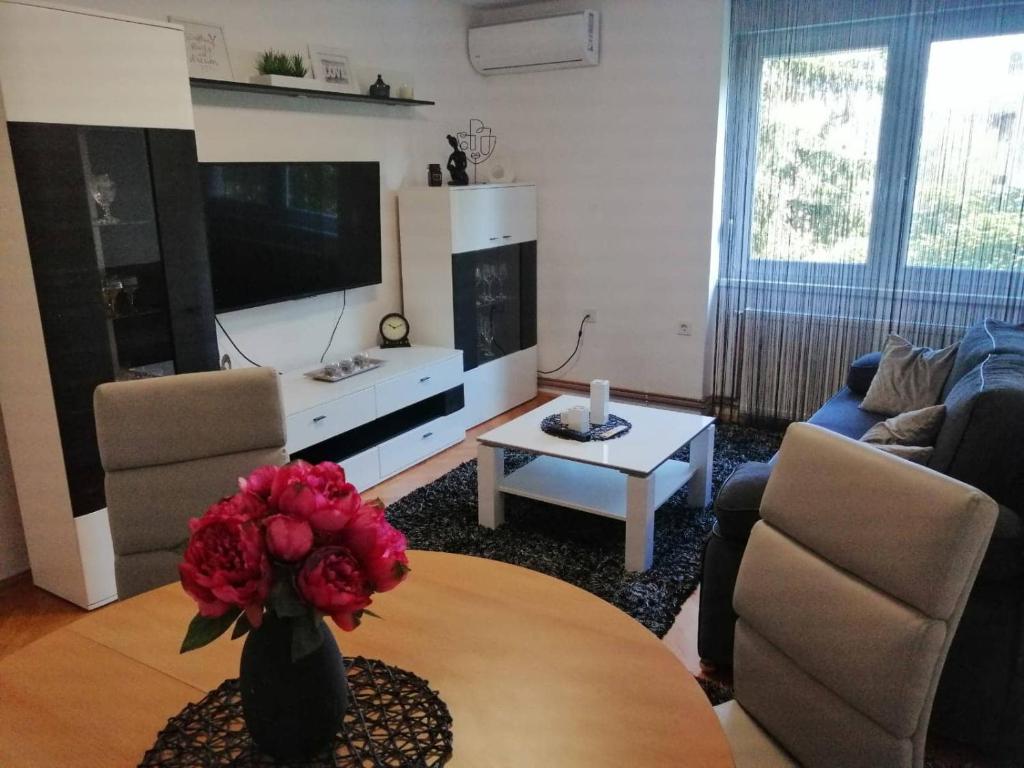 a living room with a vase of flowers on a table at APARTMAN D&D*** in Varaždin