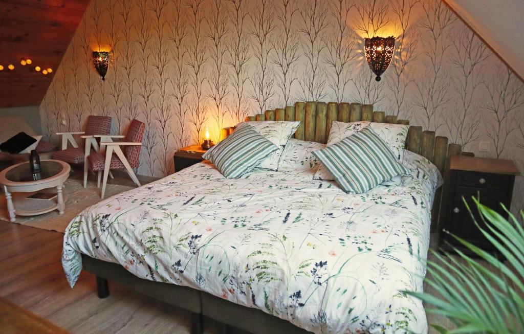 una camera con un letto e due sedie e luci di Kleene Geluk - Chambres et table d'hôtes a Saint-Jans-Cappel