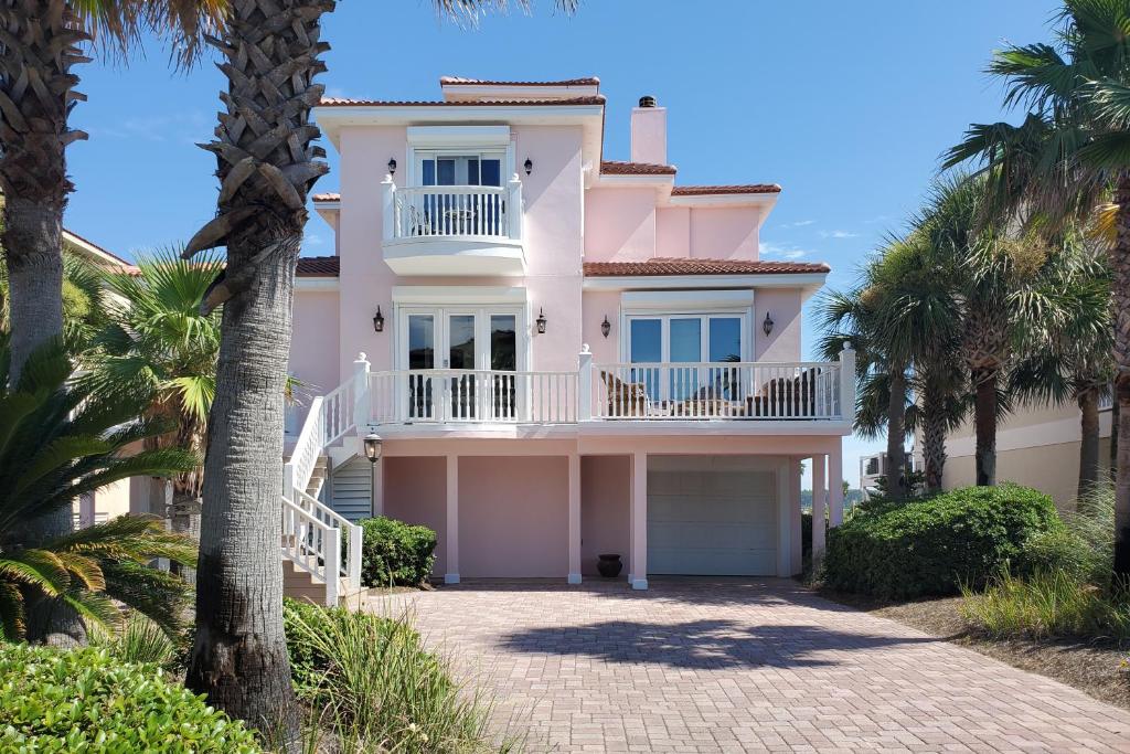 een roze huis met palmbomen ervoor bij Dad's Got It in Gulf Shores