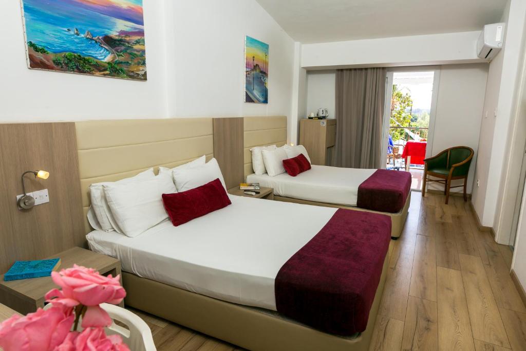 a hotel room with two beds and a table at Fitosinn Hotel in Paphos