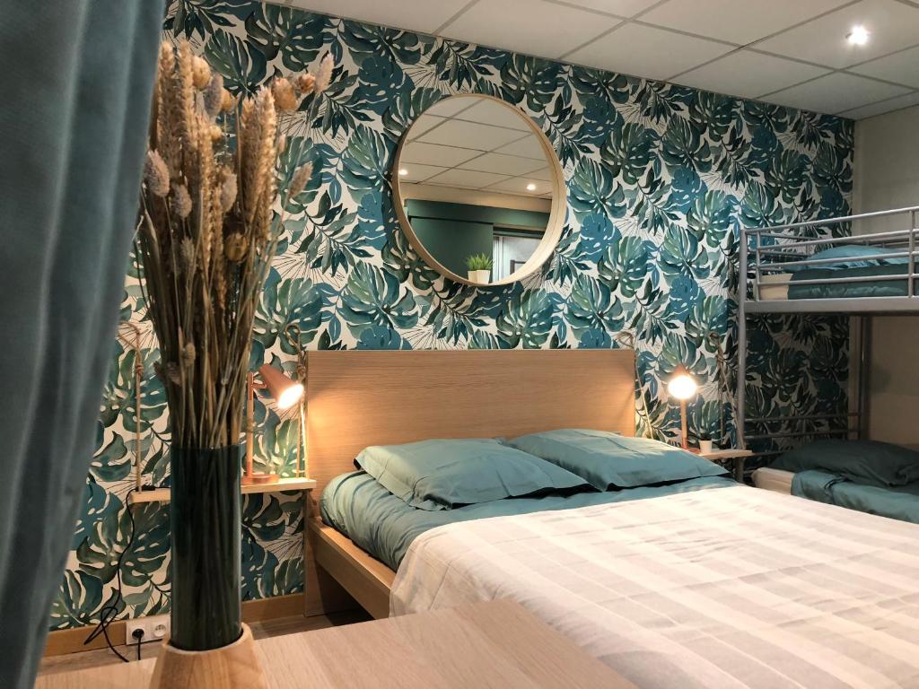 a bedroom with a bed and a mirror in it at Hotel Caplandes in Capbreton