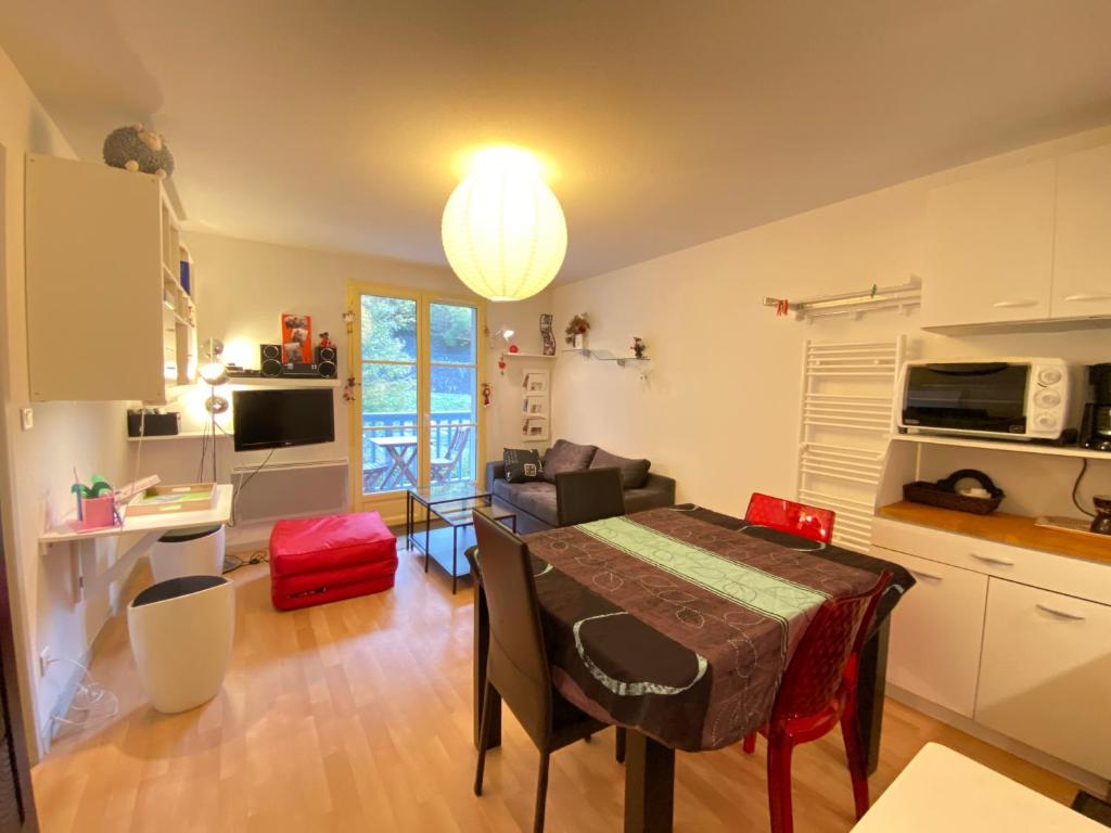 une cuisine et un salon avec une table dans la chambre dans l'établissement T2 alcove confortable pour 4 à 5p. Balcon. Parking, à Cauterets