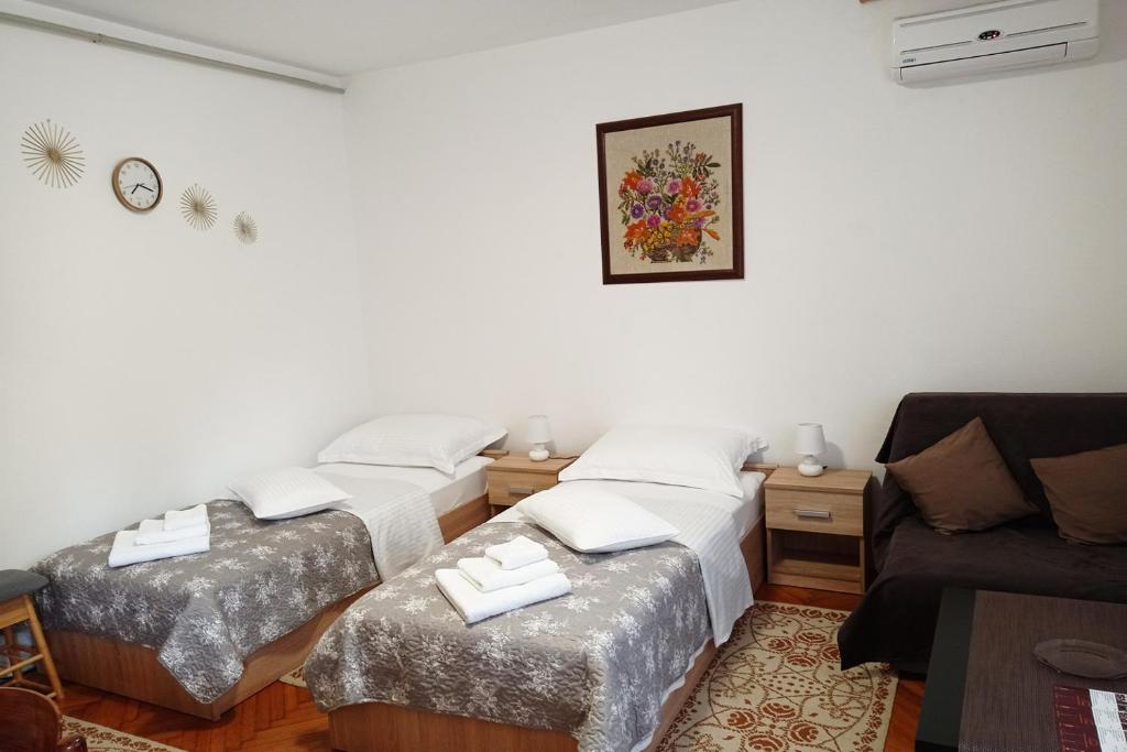 ein Wohnzimmer mit 2 Betten und einem Sofa in der Unterkunft Studio Apartman Škudar in Bjelovar