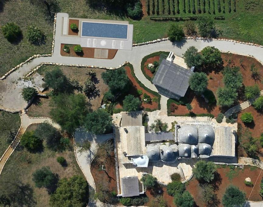 una vista aérea de una casa con un edificio en Trullidamare a Ceglie Messapica, con piscina Infinity en Cisternino
