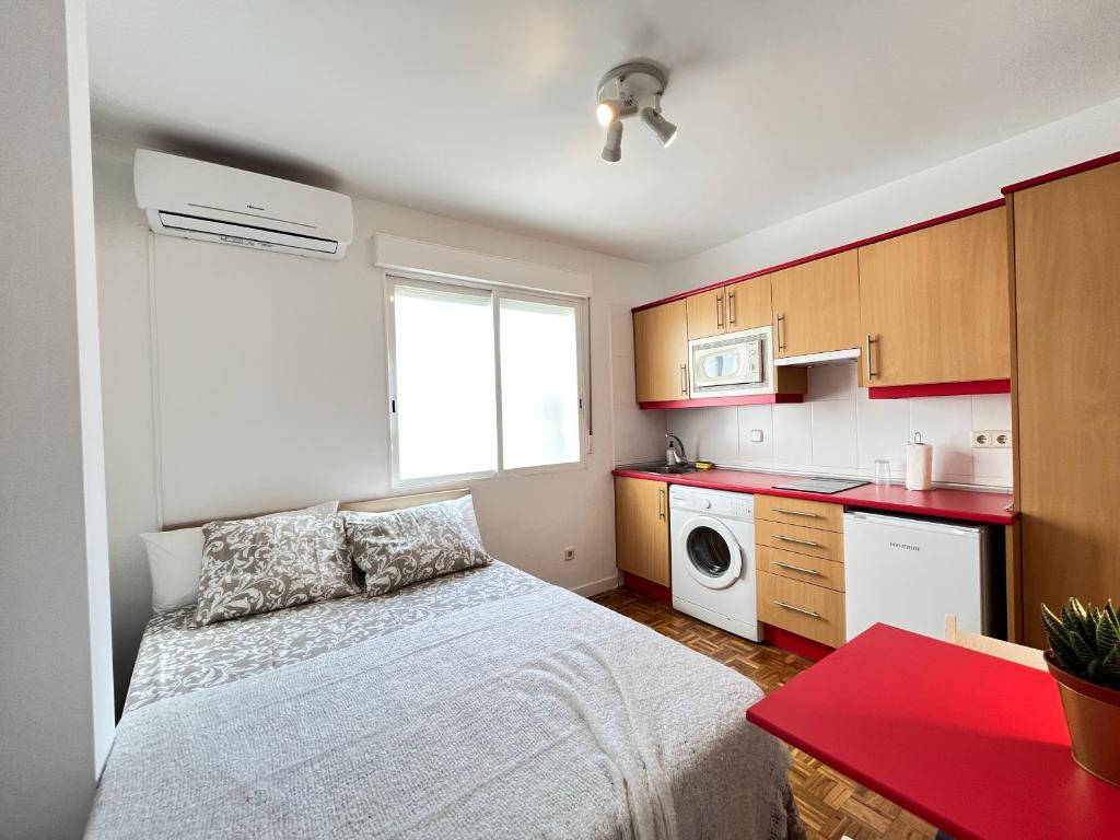 a small bedroom with a bed and a kitchen at Piso Augusto Acogedor 5 in Madrid