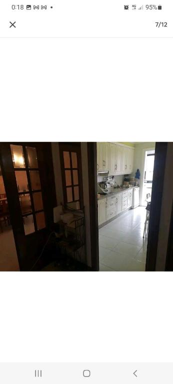 a kitchen with white cabinets and a dining room at Alojamiento bueu centro in Bueu