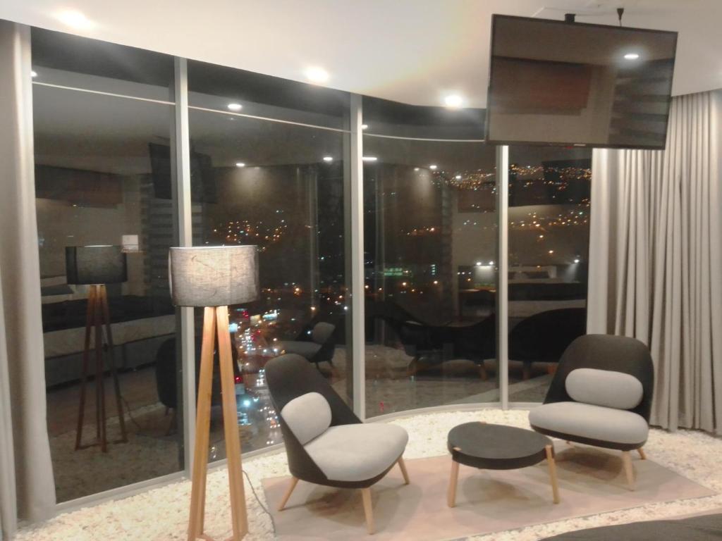 un soggiorno con due sedie e una grande finestra di Onkel Inn Apart Suites a La Paz