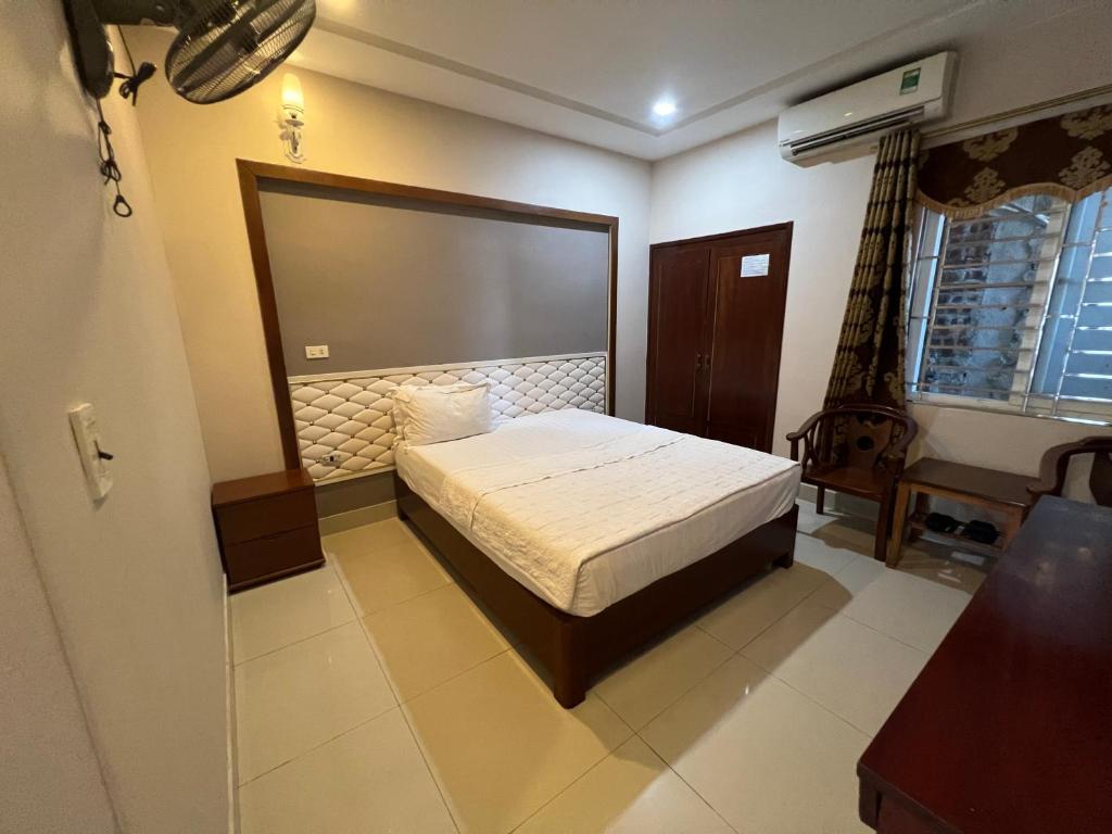 a bedroom with a bed in the corner of a room at Hoang Ngan 1 Hotel - TP. Vinh in Vinh