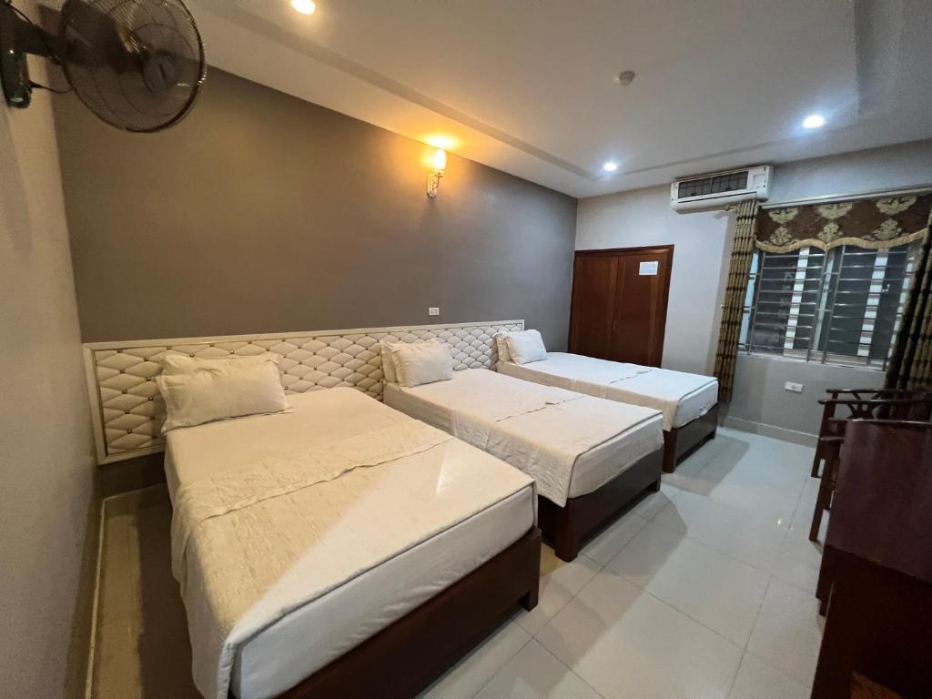 a hotel room with two beds and a window at Hoang Ngan 1 Hotel - TP. Vinh in Vinh